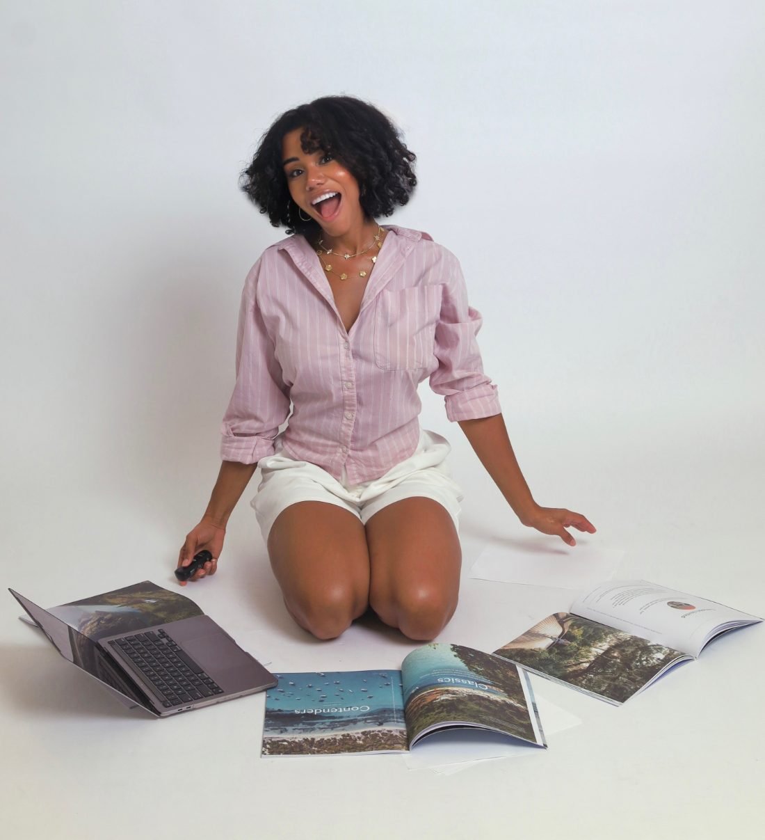 Bee, laughing, surrounded by travel magazines